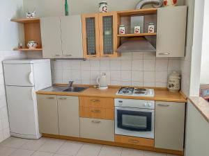 a small kitchen with a stove and a refrigerator at Keran 2+2 in Podgora +4 photos