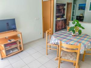 a dining room with a table and a tv at Keran 2+2 in Podgora