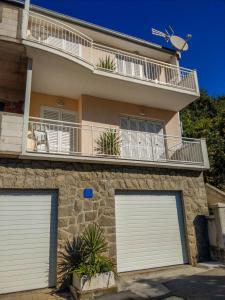 a building with two garage doors and a balcony at Keran 2+2 in Podgora