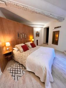 1 dormitorio con 1 cama grande y pared de madera en L'élégante en Saint-Paul-de-Vence