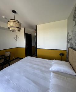 um quarto com uma grande cama branca num quarto em DOMAINE DU GRAND CAUGY em Saint-Vigor-le-Grand