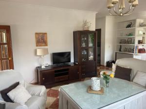 a living room with a tv and a table at Casa San Rafael con piscina in Córdoba