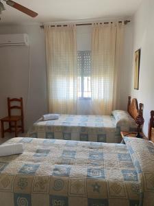 a bedroom with two beds and a window at Casa San Rafael con piscina in Córdoba