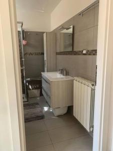 a small bathroom with a sink and a shower at Appartamento Olga nel centro storico di Intra in Intra