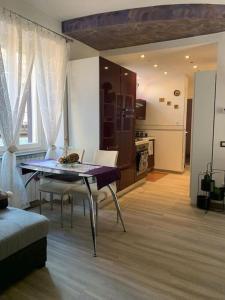 a living room with a table and chairs and a kitchen at Appartamento Olga nel centro storico di Intra in Intra