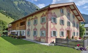 ein großes Haus mit einem Zaun vor einem Berg in der Unterkunft Residenz 111 in Holzgau