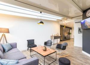 a living room with a couch and chairs and a table at Deux logements voisins au calme Olivia et Victoria in Saint-Pair