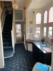 a room with a staircase with a desk and a stair case at The Monarch in Lytham St Annes