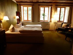 two beds in a room with two windows at Hotel und Gasthof Dreibeiniger Hund in Görlitz