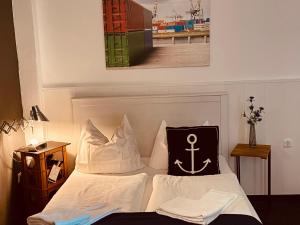 a bed with a pillow with an anchor on it at City Hostel by beans parc in Wilhelmshaven