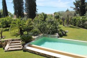 a swimming pool in a garden with trees and grass at Villa Ty Laouen- villa confort avec piscine et jacuzzi- Parc -Opio-Valbonne in Opio
