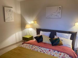 Villa Ty Laouen في Opio: غرفة نوم مع سرير مع رسومين على الحائط