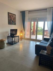 uma sala de estar com um sofá azul e uma televisão em Appartamento Addaura/Mondello em Palermo