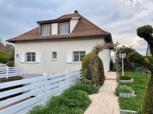 uma casa branca com uma cerca branca em Le papillon,Logement cosy en Alsace em Erstein