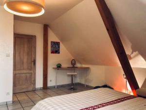 a bedroom with a bed and a table in a room at Le papillon,Logement cosy en Alsace in Erstein