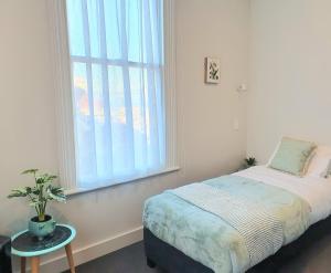 1 dormitorio con cama y ventana grande en Work Stay at 123, en Dunedin