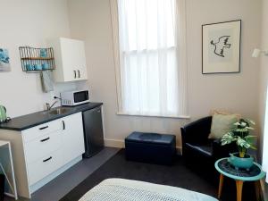 a small kitchen with a sink and a chair in a room at Work Stay at 123 in Dunedin