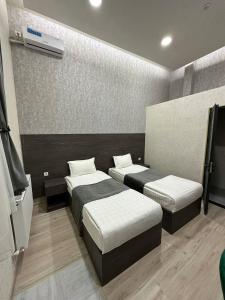ein Hotelzimmer mit 2 Betten und einem TV in der Unterkunft Hotel Sevinch in Taschkent