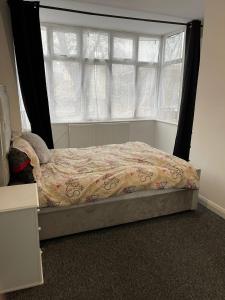 a bedroom with a bed and a window with curtains at The Botley Road House in Oxford