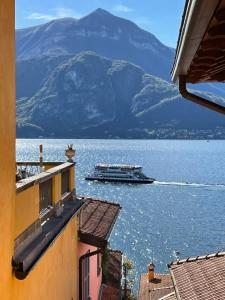 a large boat in the water with a mountain at Varennahouse in Varenna