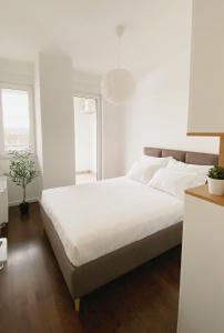 um quarto branco com uma cama grande e uma janela em Park & Play em Banja Luka