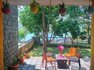 a patio with chairs and a table with flowers on it at Portofino TreeHouse in Lavasa