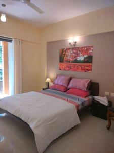 1 dormitorio con 1 cama grande con almohadas rojas en Portofino TreeHouse, en Lavasa
