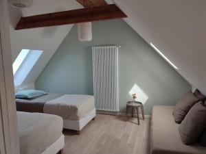 a attic room with two beds and a couch at Chambres et tables d'hôtes Cornec in Ploubazlanec