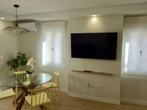 a dining room with a table and a television on a wall at La Villa de Jaén - Catedral in Jaén