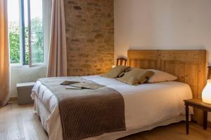 a bedroom with a large bed with a wooden headboard at Laiterie de Tocqueville in Tocqueville