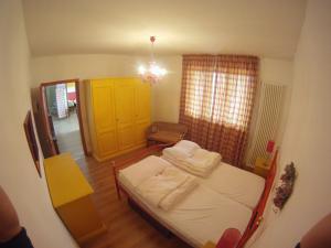 een kleine slaapkamer met een bed en een gele kast bij red house conditioned whit pool enchanting lake view in Malcesine +28 foto's