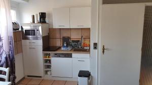 una piccola cucina con armadietti bianchi e forno a microonde di Blütenzauber Apartment No 1 a Mittelnkirchen