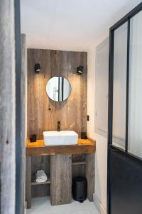 een badkamer met een wastafel en een spiegel bij Maison Maleville in Domme