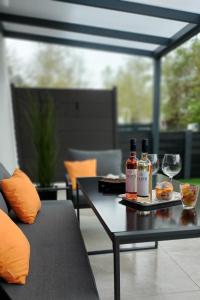 a table with two bottles of wine and glasses on it at Kikötő Sétány Apartman I. in Balatonszemes