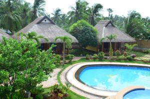 a resort with a swimming pool and two huts at Veraneante Resort in Panglao