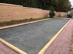 un parking vide à côté d'un mur de briques dans l'établissement Le mas contemporain de Dun, à Dun-le-Palestel