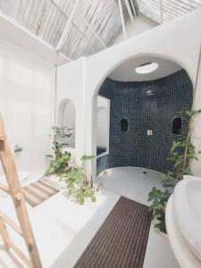 a bathroom with a toilet and a blue tile wall at Naturetalk Farmstay 3 bedrooms in Ban Don