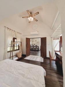 a bedroom with a bed and a ceiling fan at Naturetalk Farmstay 3 bedrooms in Ban Don