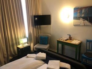 ein Hotelzimmer mit einem Bett, einem Stuhl und einem Schreibtisch in der Unterkunft City Hostel by beans parc in Wilhelmshaven