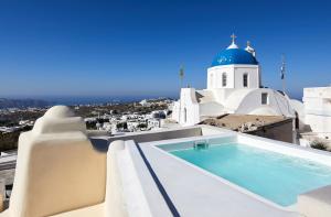 a pool on the roof of a house with a church at Thiro Exclusive Villa with private jacuzzi in Pyrgos