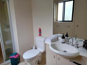 a white bathroom with a toilet and a sink at Tingalpa Townhouse Treat in Brisbane +28 photos