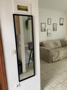 a mirror in a living room with a couch at L&L in Okrug Gornji