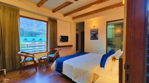 Un dormitorio con una cama y una ventana grande. en Yaato Retreat, en Manali