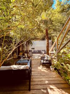 una terraza de madera con sillas, mesa y árboles en La Cabane du Bois, en Arcachon