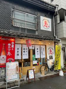 a building with signs on the front of it at Namba Shinsaibashi 10 mins Reiko guest house in Osaka