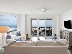 a living room with a couch and a view of the ocean at Beach Colony Towers #2B - Villa Monarch in Perdido Key