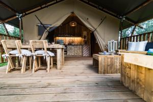 a tent with two chairs and a table in it at Glamping Tenuta Poggio Rosso in Populonia