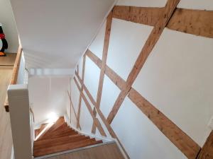 a staircase in a house with wooden beams at FeWo im Lehm-Fachwerkhaus Erfurt mit 3 einzelnen Schlafzimmern je mit TV in Erfurt