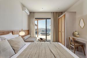 a bedroom with a bed and a desk with a view at Ambeli Sunset Villas in Megalokhori