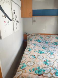 a bed with a quilt with hearts on it in a room at Mobil home climatisé au Domaine Lalande à Mimizan in Mimizan